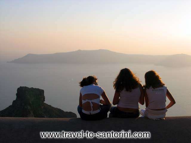 GIRLS - Three girls watching the sunset from a roof in Imerovigli