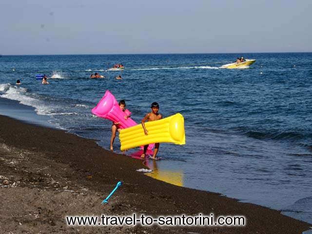 KIDS - Two kids on the beach of Agios Georgios in Santorini