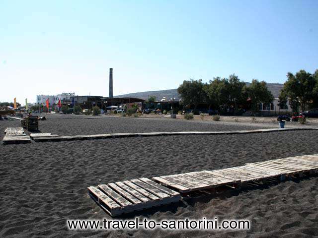 Agios Georgios Beach - View of the beach to the west towards Agios Georgios with the old tomato factory in the background