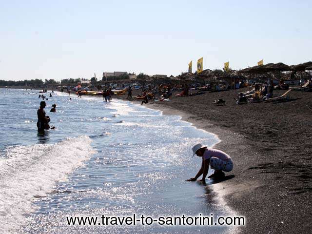 WOMAN WASHING HANDS - View of the several km long beach. A woman is washing her hands in the sea.